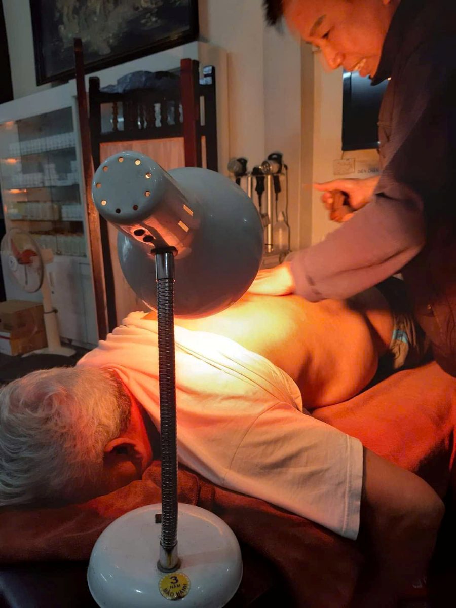 Chiếu đèn sưởi hồng ngoại làm ấm vùng lưng trong buổi trị liệu